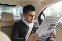 car uber man reading newspaper